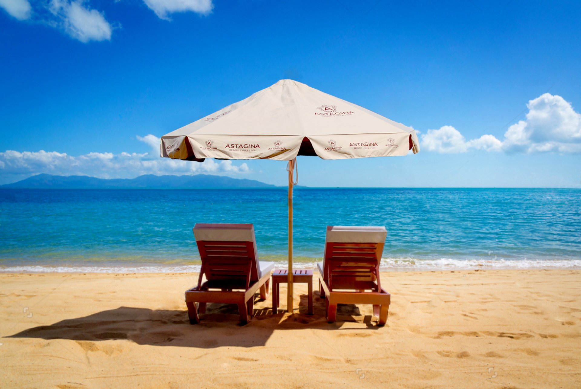 Beachfront sun loungers and umbrella near Astagina Resort with ocean views in Bali.