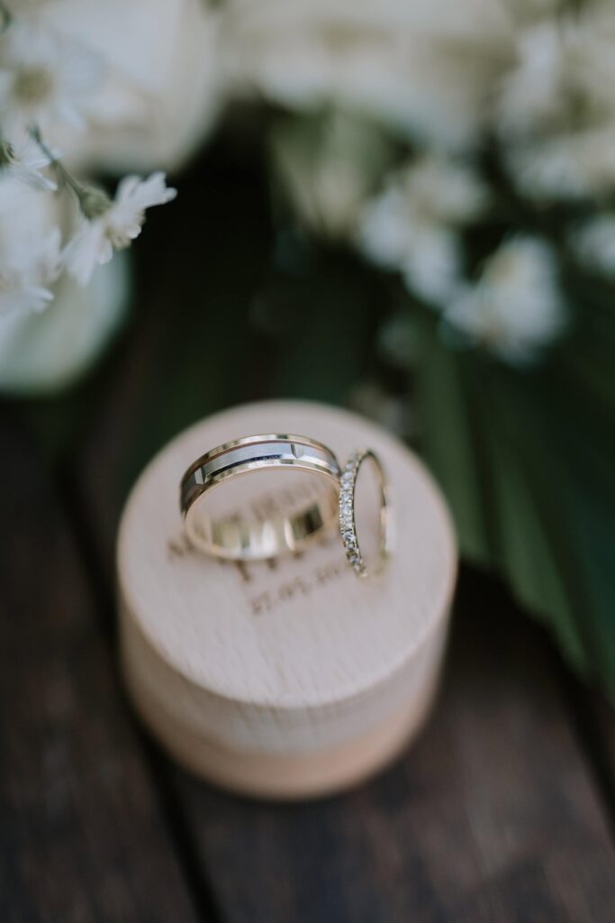 Wedding rings on wooden ring box surrounded by greenery details from a Bali garden wedding at Astagina Resort Villa & Spa Legian
