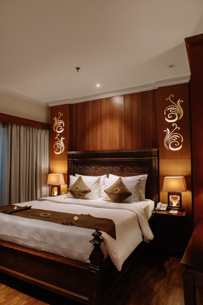 Family-friendly suite bedroom with wooden design interior at Astagina Resort Villa and Spa Legian Bali
