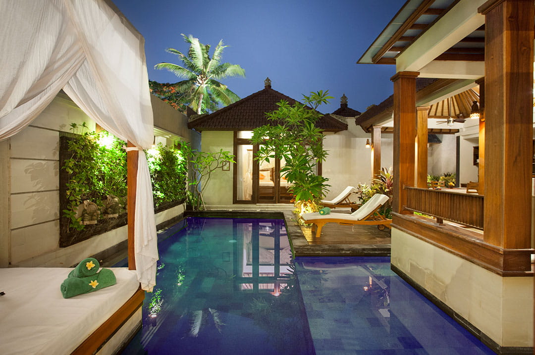 Private pool villa at Astagina Resort Legian with tropical garden and outdoor lounge area